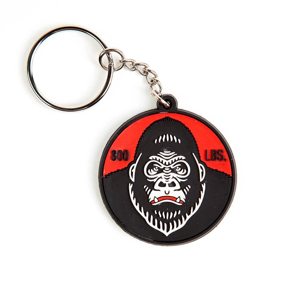 A round rubber keychain in black and red with a gorilla face.