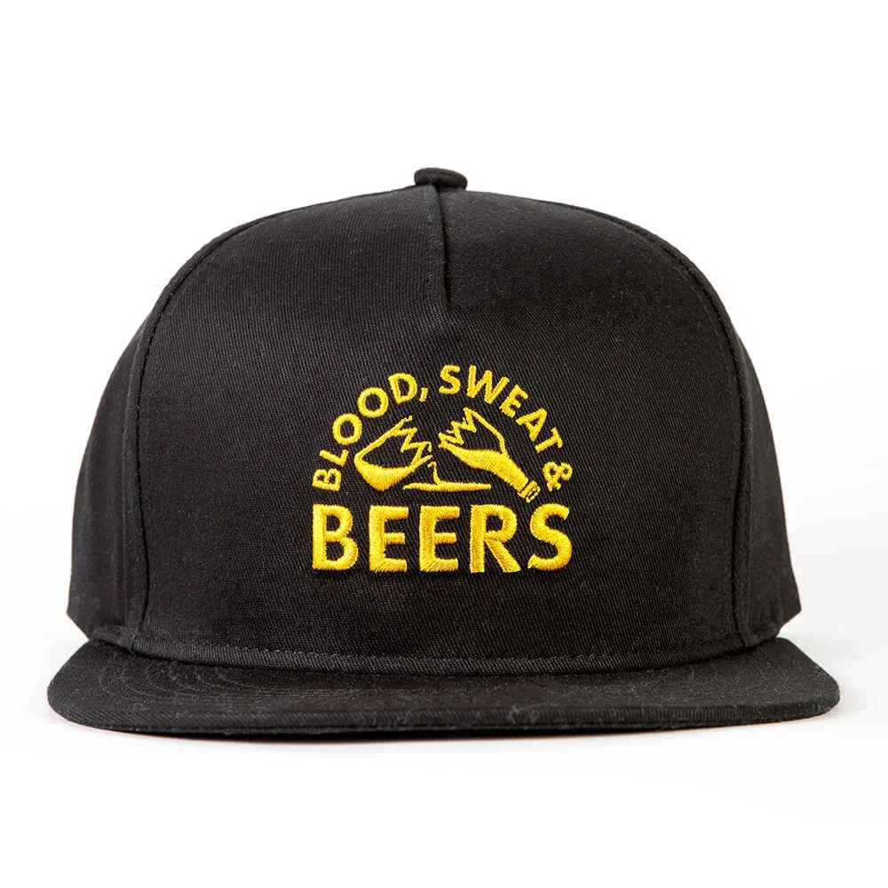 Black snapback cap with yellow embroidery arched over two clinking bottles.