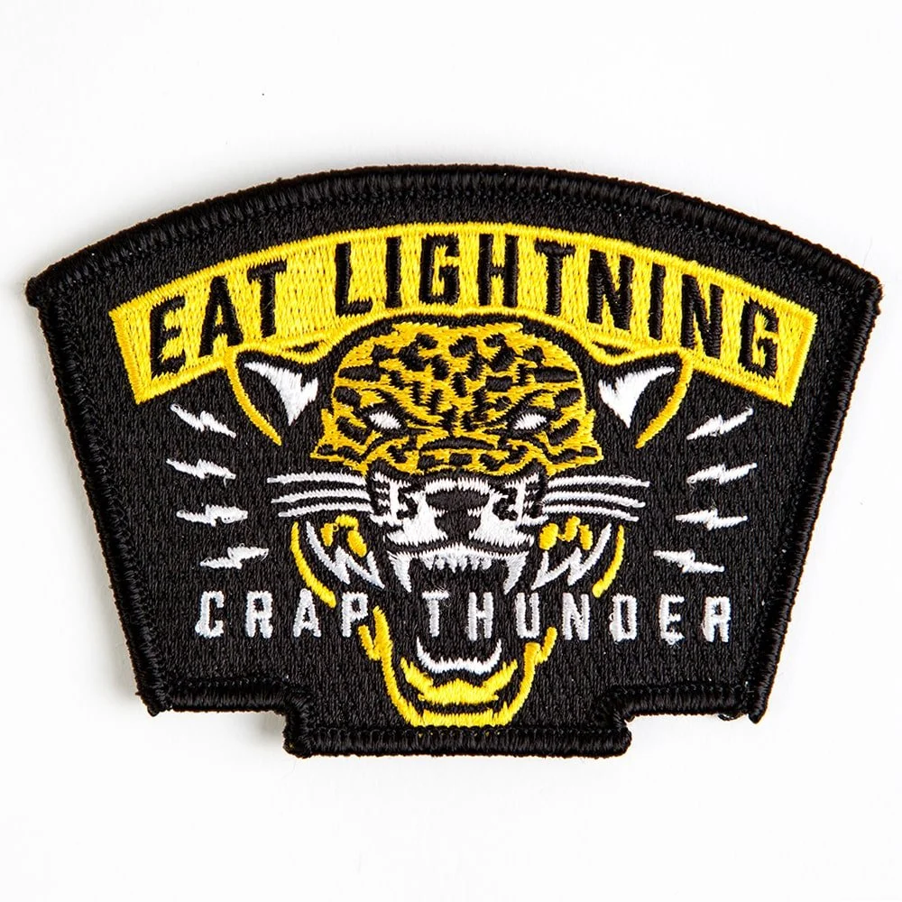 An embroidered patch with a yellow leopard head on black twill.