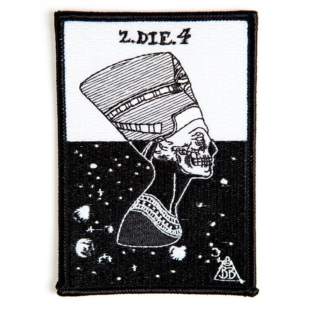 A rectangular embroidered patch, a skull in a headdress against a night sky.